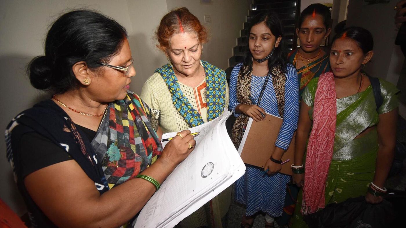 Census workers interview a woman.