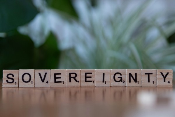 Pieces of a board game (such as Scrabble) making up the letters to the word SOVEREIGNTY.